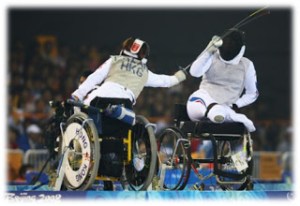 Duas pessoas com deficiência em cadeira de rodas praticam esgrima